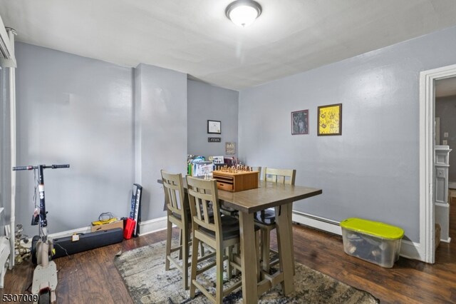 dining room with baseboards, baseboard heating, and wood finished floors