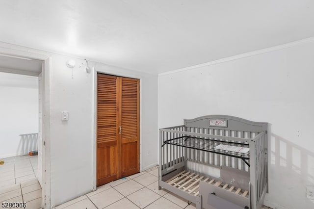 tiled bedroom with a closet and a nursery area