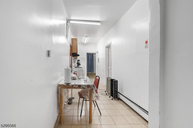 corridor featuring baseboard heating and light tile patterned floors