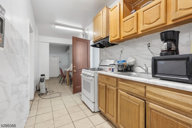 kitchen featuring backsplash, sink, range hood, white gas stove, and light tile patterned floors