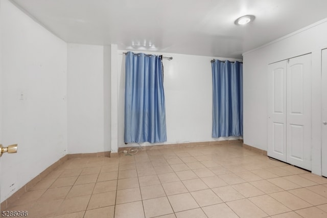 unfurnished bedroom featuring light tile patterned floors and a closet