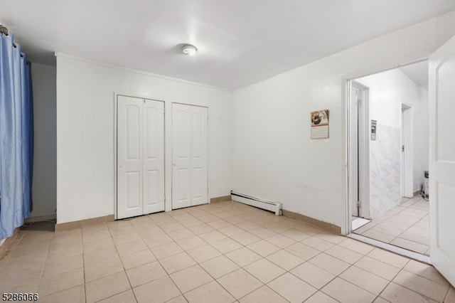 unfurnished bedroom featuring baseboard heating and light tile patterned floors