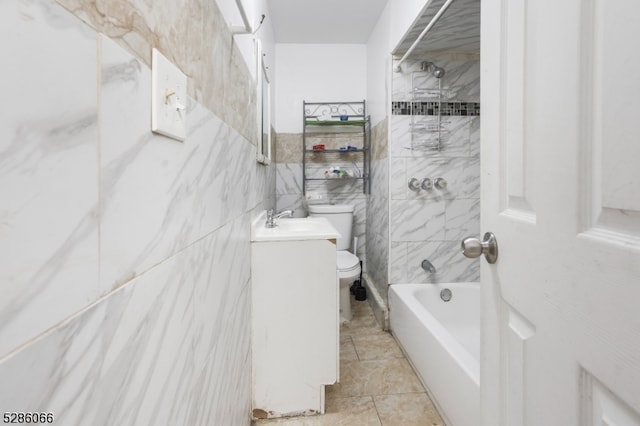 full bathroom with vanity, tile patterned floors, tile walls, toilet, and tiled shower / bath combo