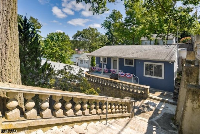 ranch-style house with a shingled roof and a chimney