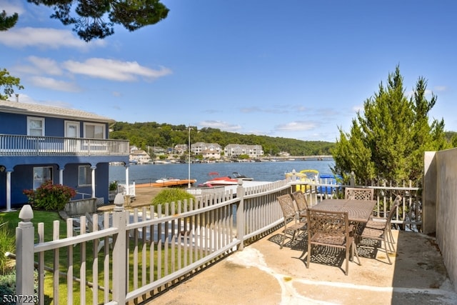 view of patio featuring a water view and a balcony