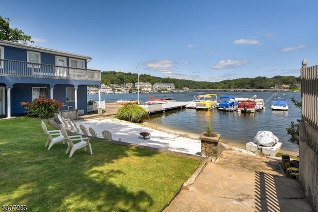 dock area with a lawn, a patio, and a water view