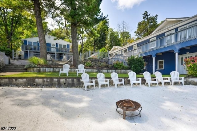 surrounding community featuring a fire pit and a water view