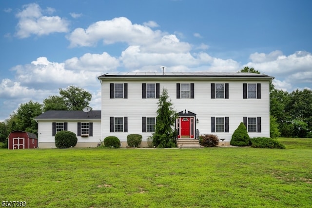 colonial house featuring a storage shed and a front yard