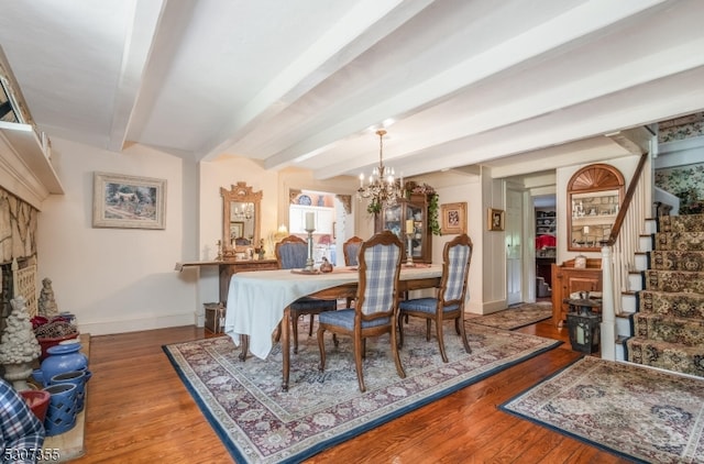 dining space featuring beam ceiling, hardwood / wood-style floors, and a chandelier