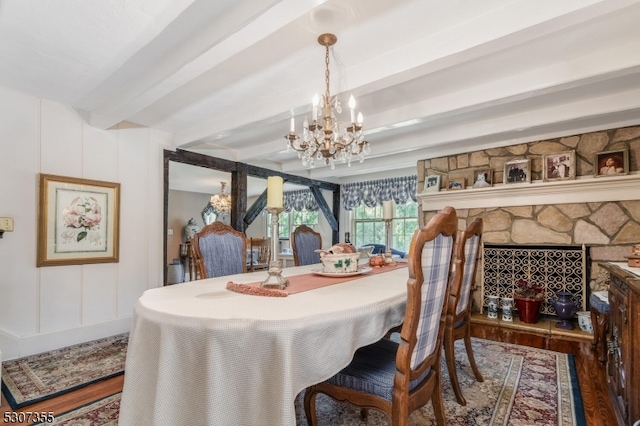 dining area featuring an inviting chandelier, beam ceiling, and wood-type flooring