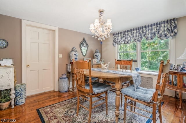 dining area with a notable chandelier and hardwood / wood-style flooring