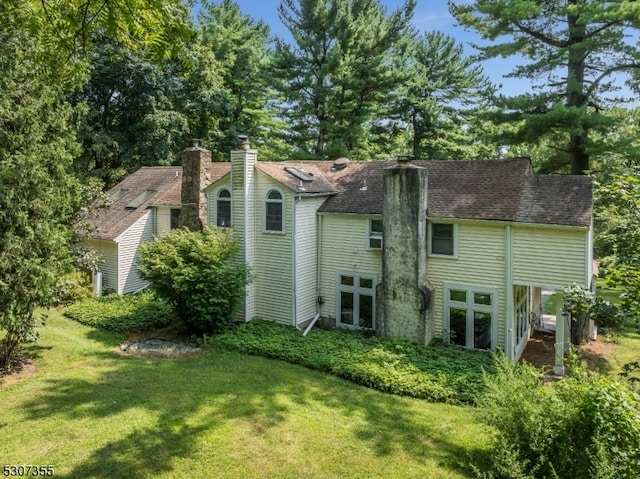 back of house with french doors and a yard