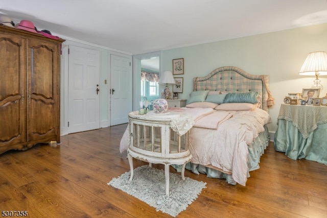 bedroom featuring crown molding and wood-type flooring