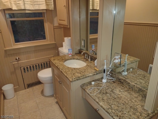 bathroom featuring toilet, tile patterned flooring, vanity, radiator heating unit, and wood walls