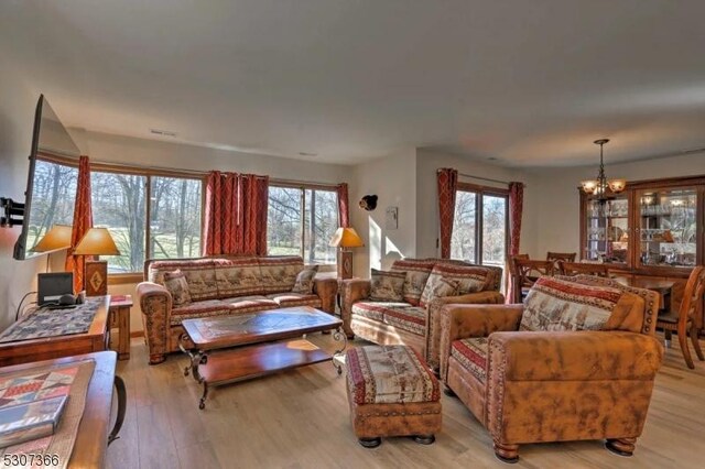 living room featuring light hardwood / wood-style flooring and an inviting chandelier