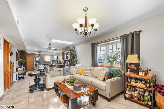 living room featuring radiator heating unit, ceiling fan with notable chandelier, and light tile patterned floors