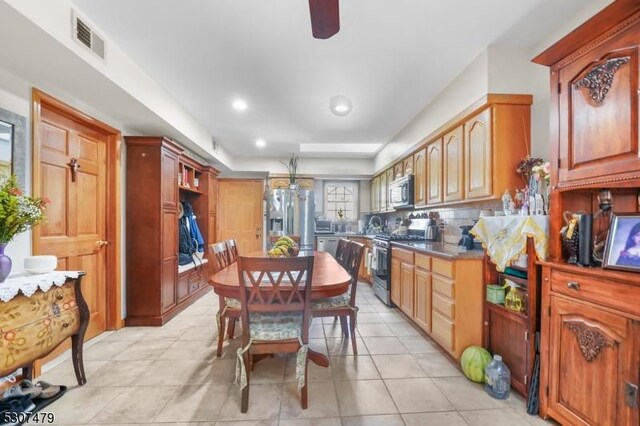 kitchen featuring light tile patterned floors, backsplash, and stainless steel appliances