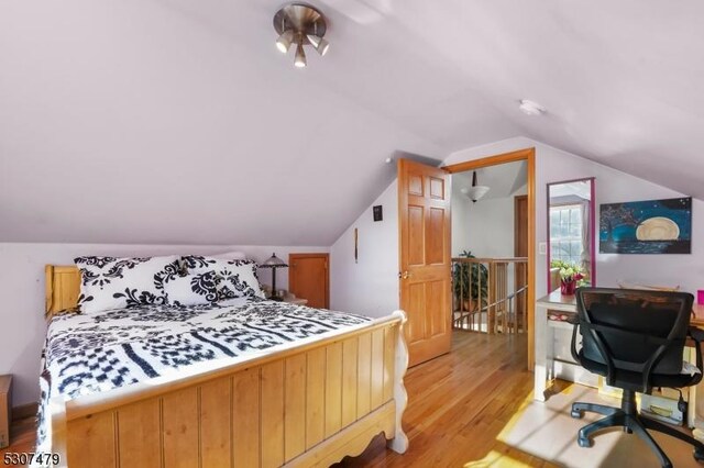 bedroom with light hardwood / wood-style flooring and lofted ceiling