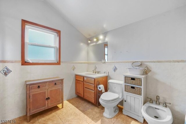 bathroom with tile walls, tile patterned floors, a bidet, and lofted ceiling