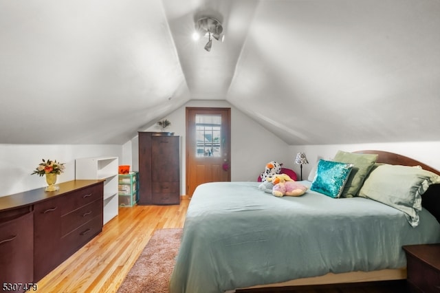 bedroom featuring light wood-type flooring and vaulted ceiling