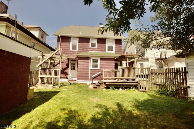 back of property with a lawn and a deck