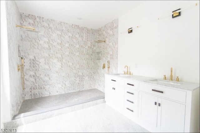 bathroom with a tile shower and vanity