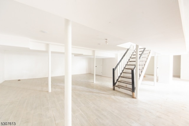 basement with light hardwood / wood-style flooring