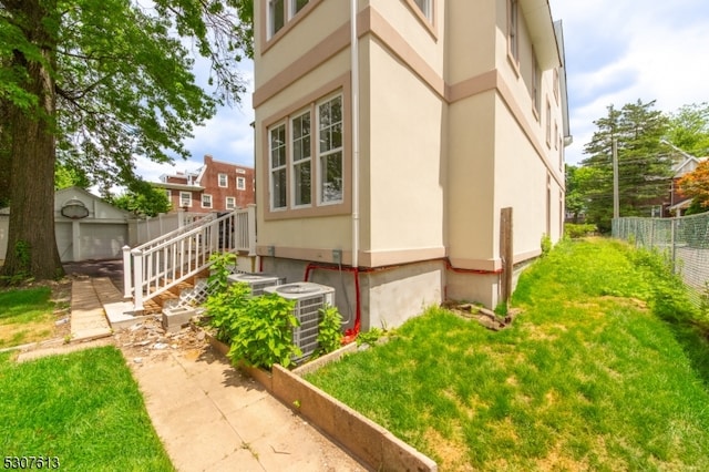 view of property exterior featuring central air condition unit and a lawn