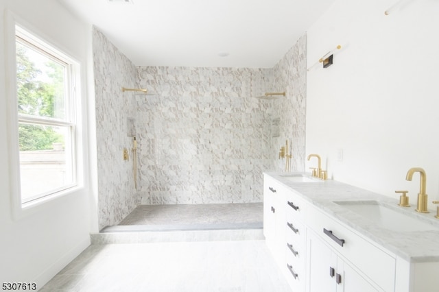 bathroom with vanity and a tile shower