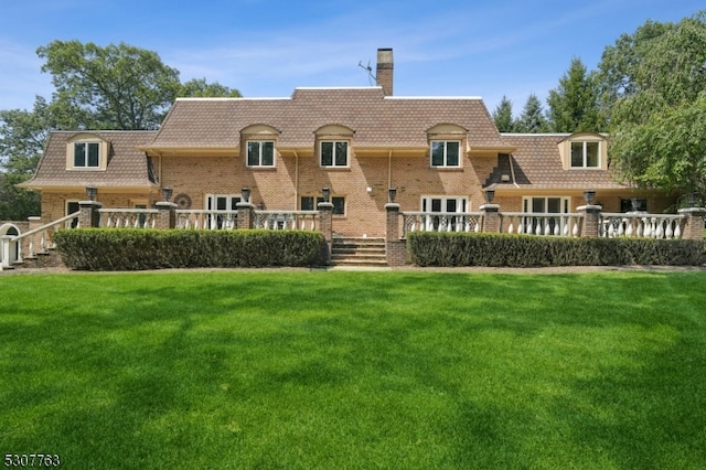 rear view of house featuring a yard