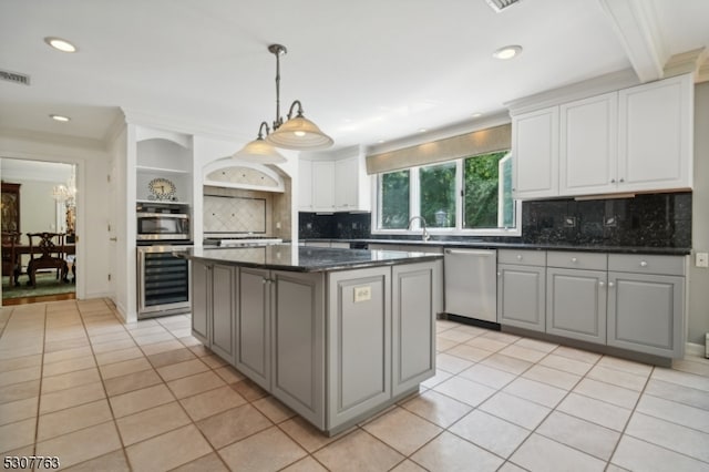 kitchen with a kitchen island, stainless steel appliances, gray cabinetry, and beverage cooler