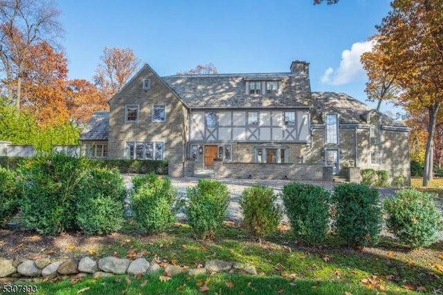 view of front of home with a sunroom and a chimney