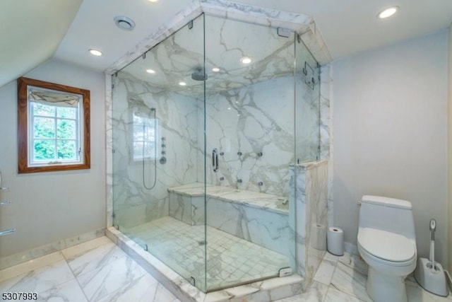 bathroom featuring toilet, marble finish floor, a marble finish shower, and vaulted ceiling