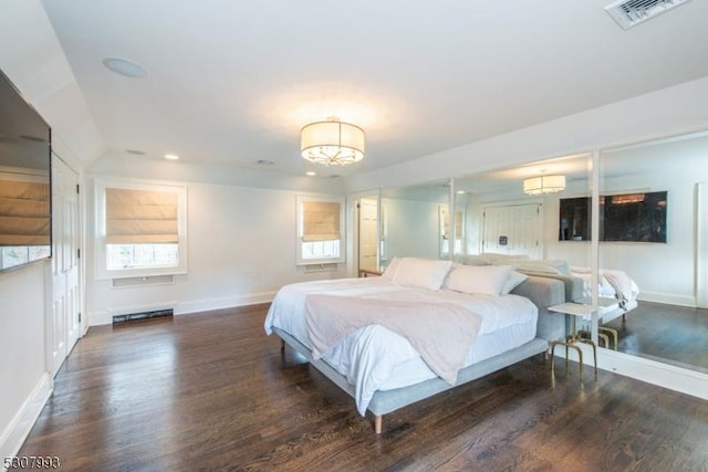 bedroom featuring multiple windows, dark wood-style flooring, visible vents, and baseboards