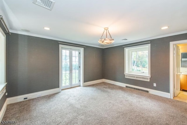 spare room with visible vents, light colored carpet, crown molding, and french doors