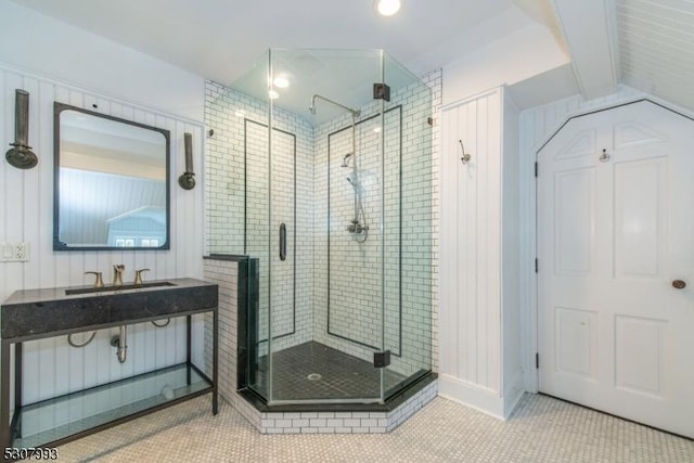 bathroom featuring tile patterned flooring, a sink, and a shower stall