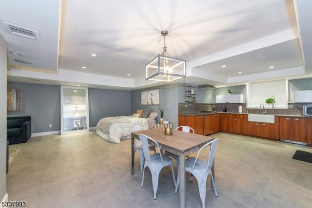 dining area featuring baseboards, a raised ceiling, visible vents, and recessed lighting