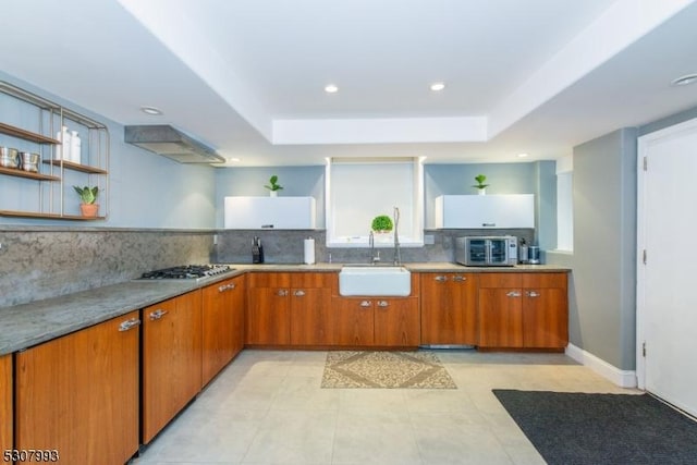 kitchen featuring light countertops, brown cabinets, and a sink