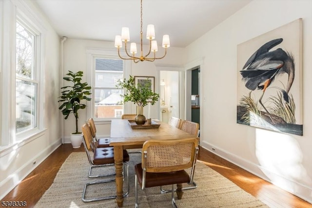 dining area with dark hardwood / wood-style floors and a chandelier