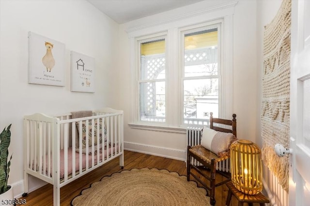 bedroom with hardwood / wood-style floors and a crib