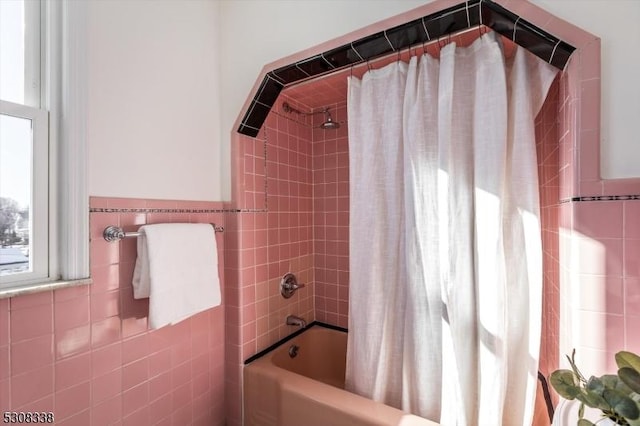 bathroom featuring tile walls and shower / tub combo