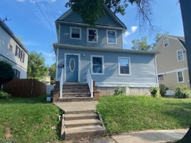 view of front of home with fence and a front lawn