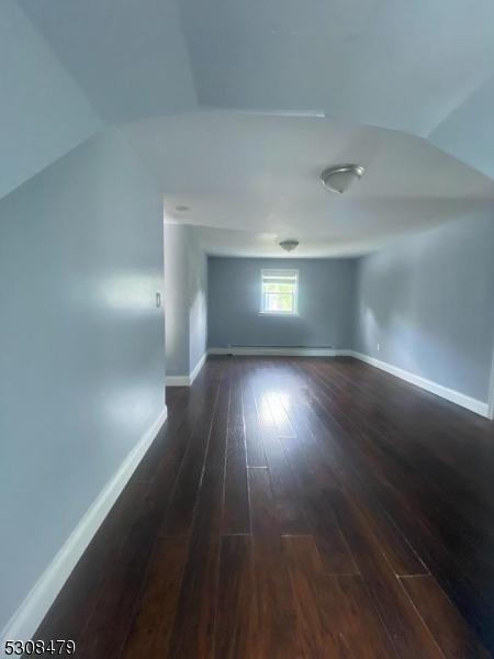 interior space featuring vaulted ceiling and dark hardwood / wood-style floors