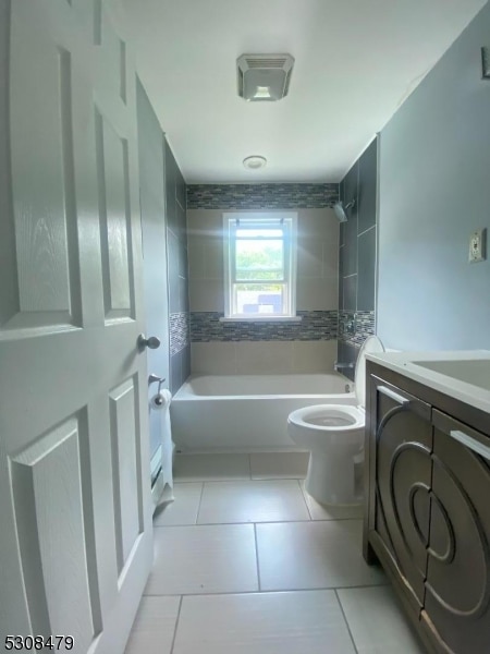 full bathroom with tiled shower / bath combo, toilet, tile patterned floors, and vanity