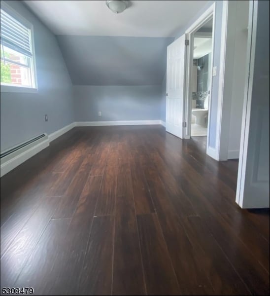 additional living space with hardwood / wood-style flooring, baseboard heating, and lofted ceiling