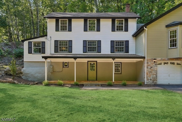 view of front facade with a porch, a front yard, and a garage