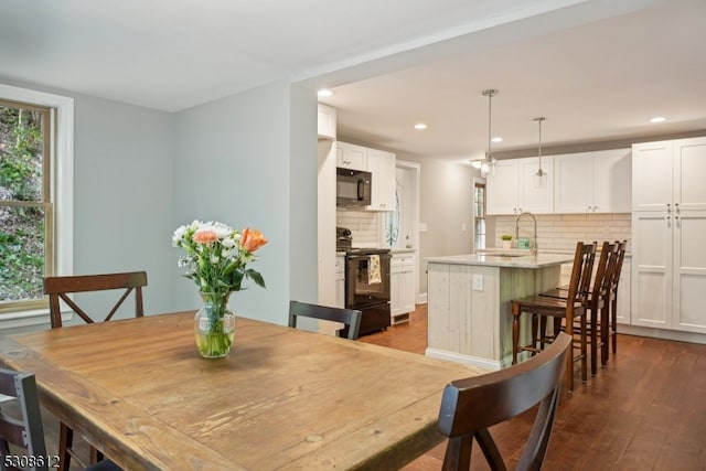 dining space featuring sink, hardwood / wood-style floors, and a wealth of natural light