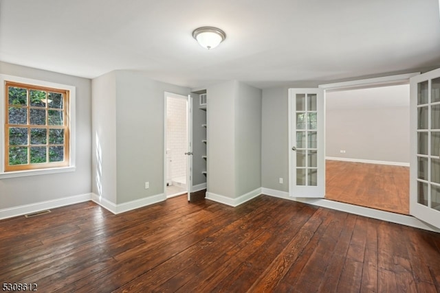 empty room featuring dark hardwood / wood-style flooring and french doors