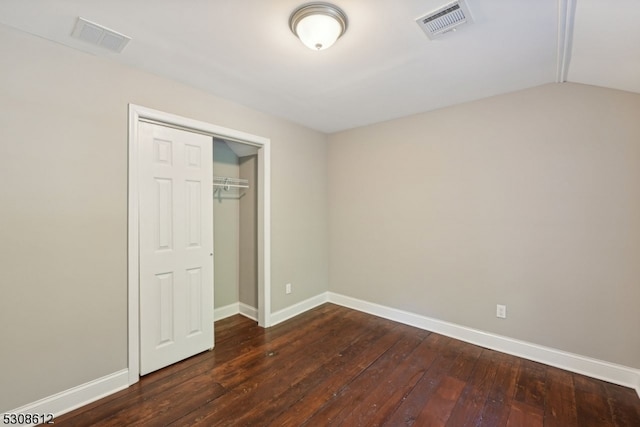 unfurnished bedroom with lofted ceiling, a closet, and dark hardwood / wood-style floors