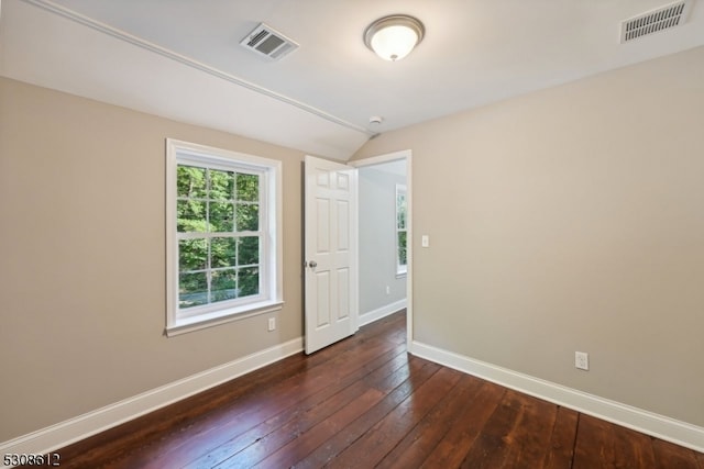 unfurnished room featuring lofted ceiling and dark wood-type flooring